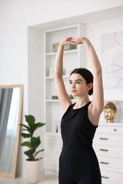 Portrait of beautiful girl practicing yoga at home