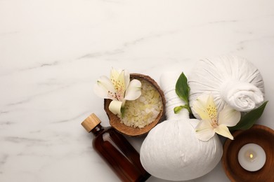 Flat lay composition with spa products and flowers on white marble table. Space for text