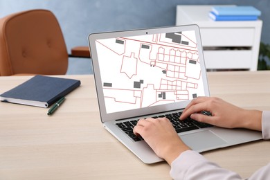 Image of Woman analyzing cadastral map on laptop at table, closeup 