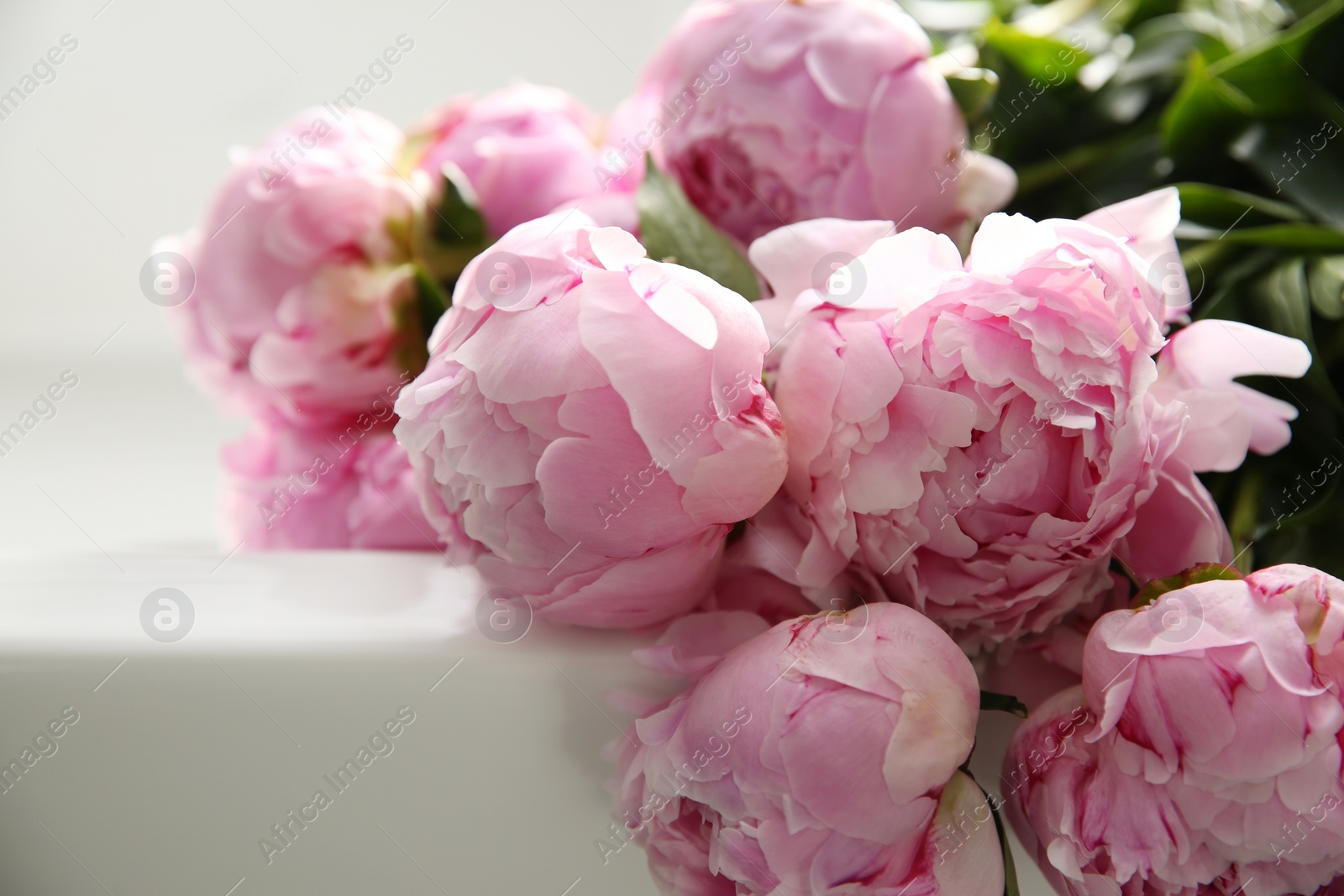 Photo of Bouquet of beautiful pink peonies on counter in kitchen, closeup