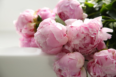 Photo of Bouquet of beautiful pink peonies on counter in kitchen, closeup