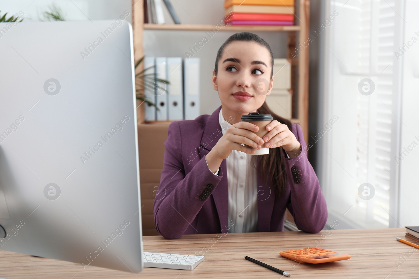 Photo of Lazy employee drinking coffee at table in office