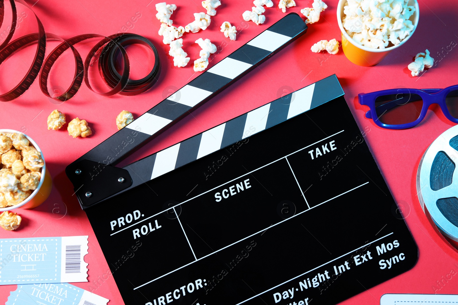 Photo of Flat lay composition with clapperboard and popcorn on red background