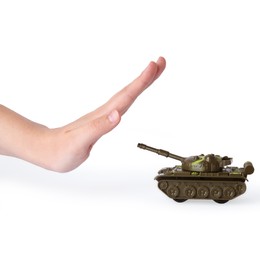 Photo of Woman showing stopping sign in front of toy tank on white background. No war concept