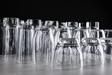 Photo of Empty glasses on marble table against black background
