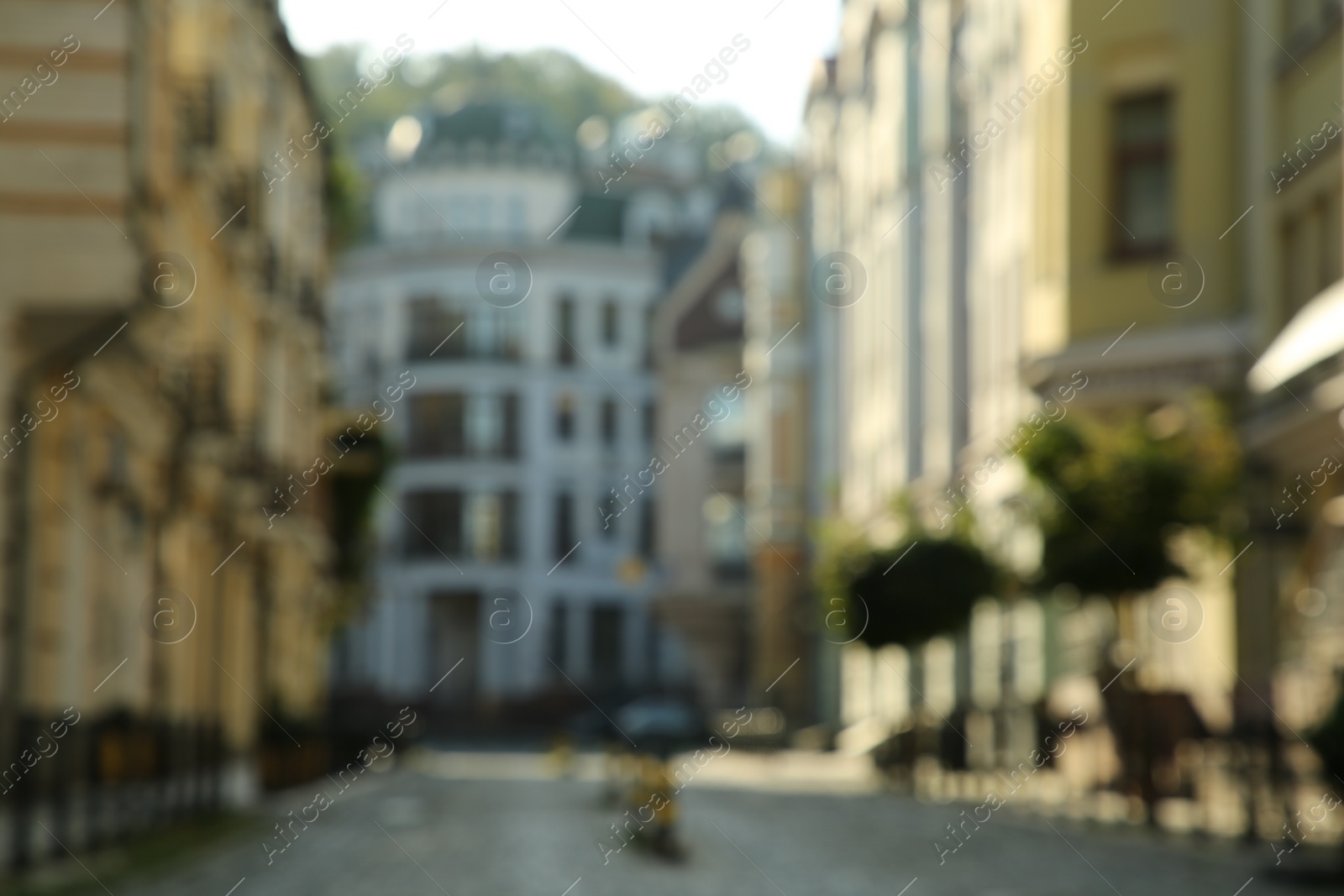 Photo of Blurred view of quiet city street with buildings on sunny day