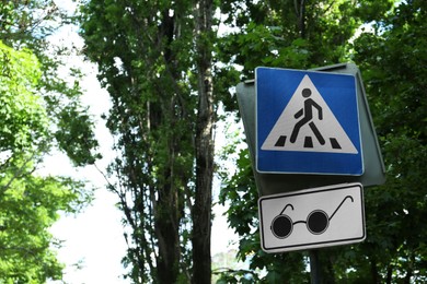 Different traffic signs near trees outdoors, space for text