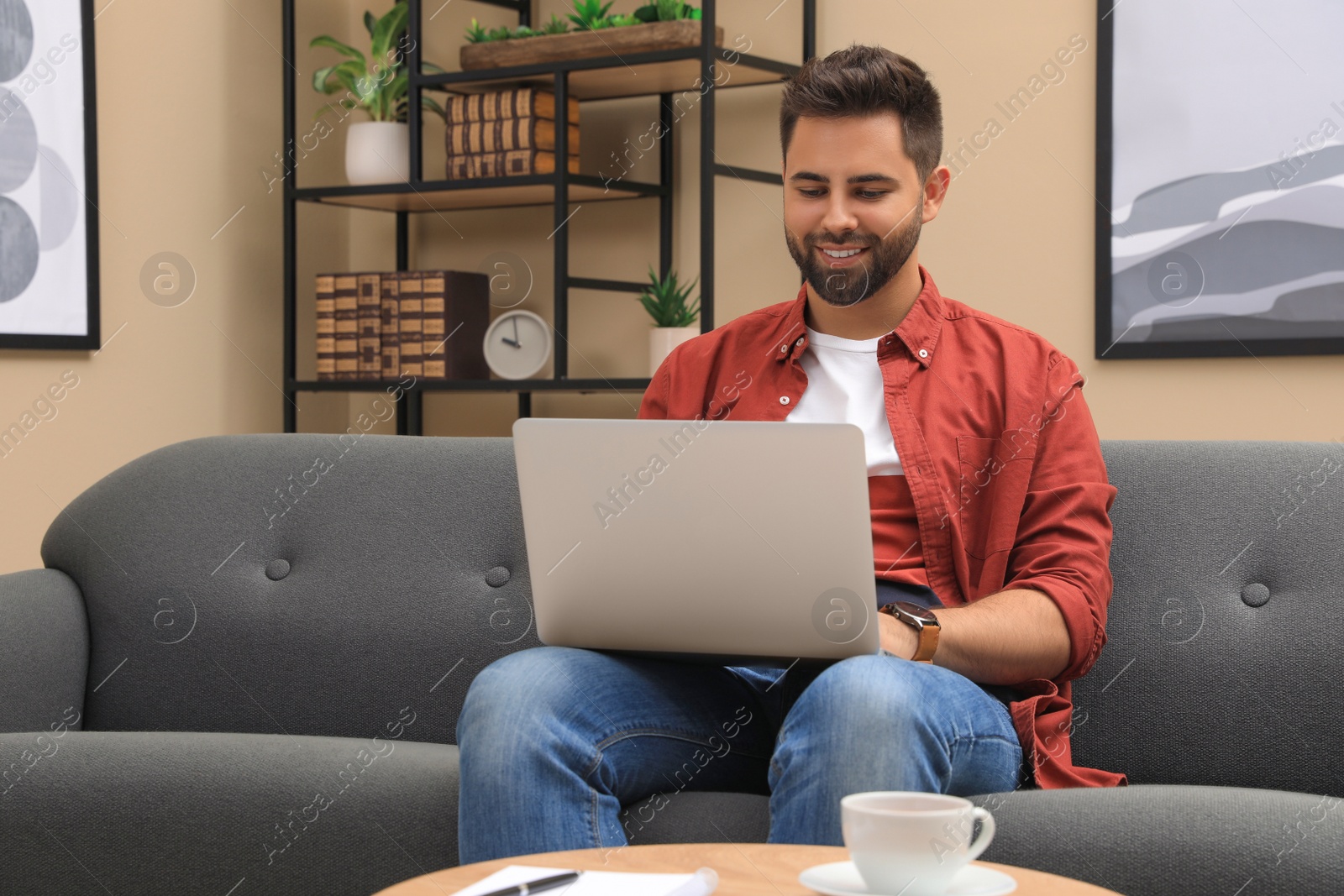 Photo of Man using laptop for online shopping at home