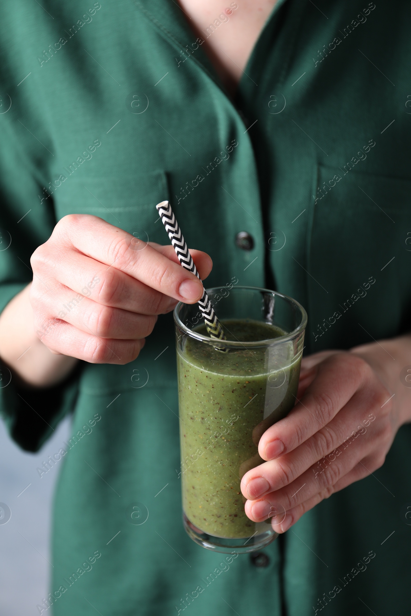 Photo of Woman with delicious kiwi smoothie on blue background, closeup