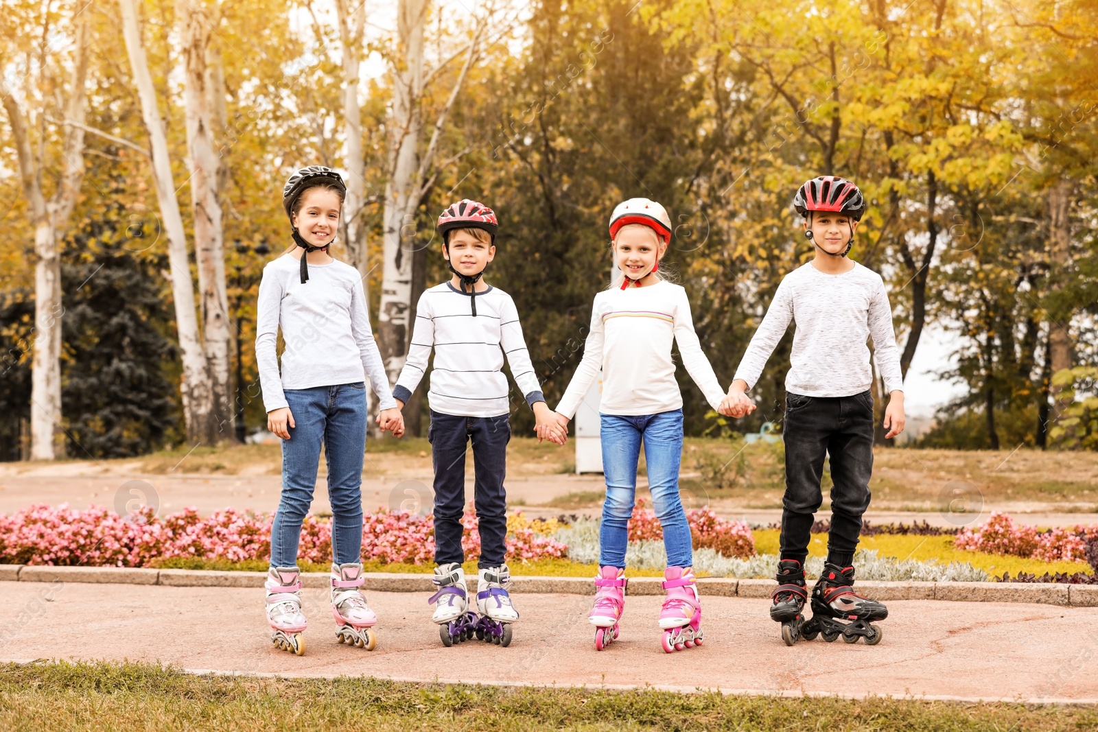 Photo of Happy children wearing roller skates in autumn park