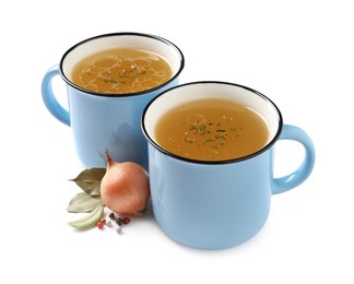 Photo of Hot delicious bouillon in cups and ingredients on white background