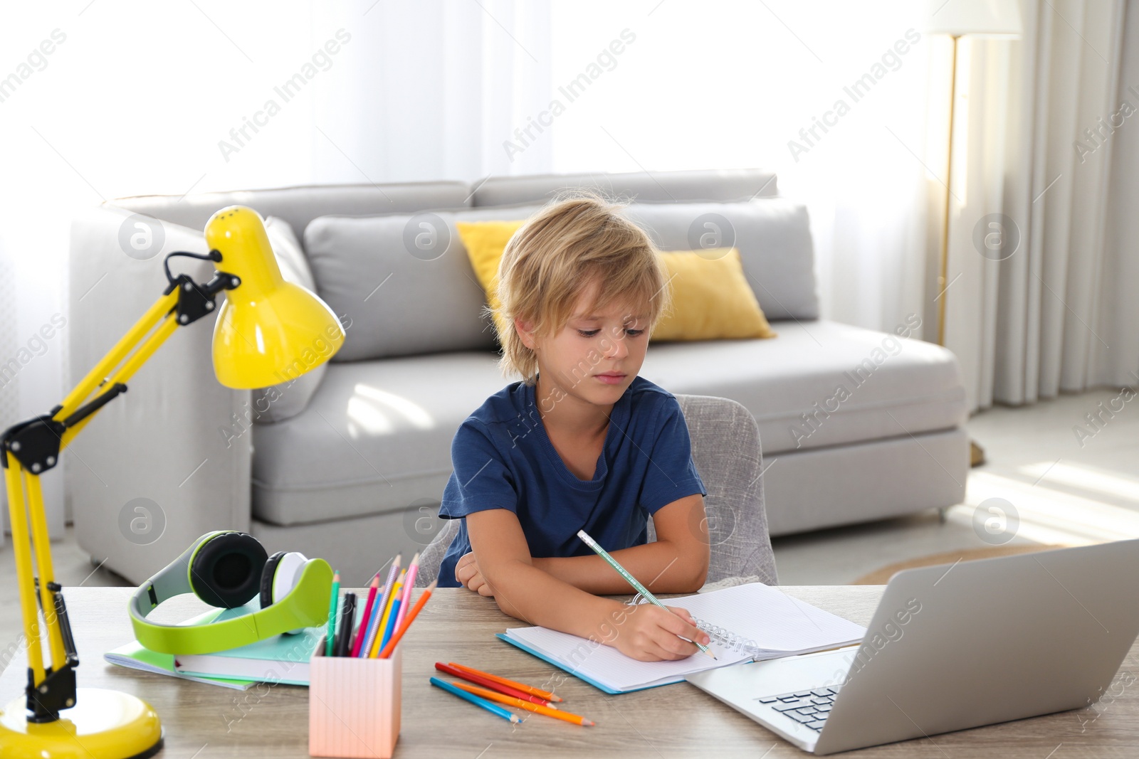 Photo of Little boy studying online at home. Distance learning during COVID-19 pandemic