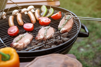 Photo of Cooking food on barbecue grill outdoors, closeup