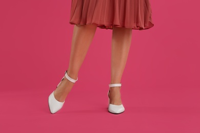 Photo of Woman wearing stylish shoes on pink background, closeup