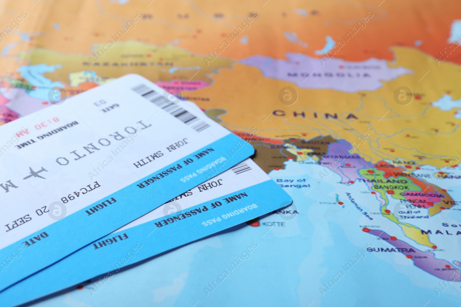 Photo of Avia tickets on world map, closeup. Travel agency concept