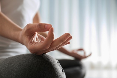 Photo of Woman practicing yoga indoors, closeup. Space for text