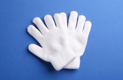 Photo of Pair of stylish woolen gloves on blue background, flat lay