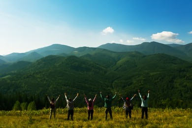 Image of Group of happy tourists on hill in mountains