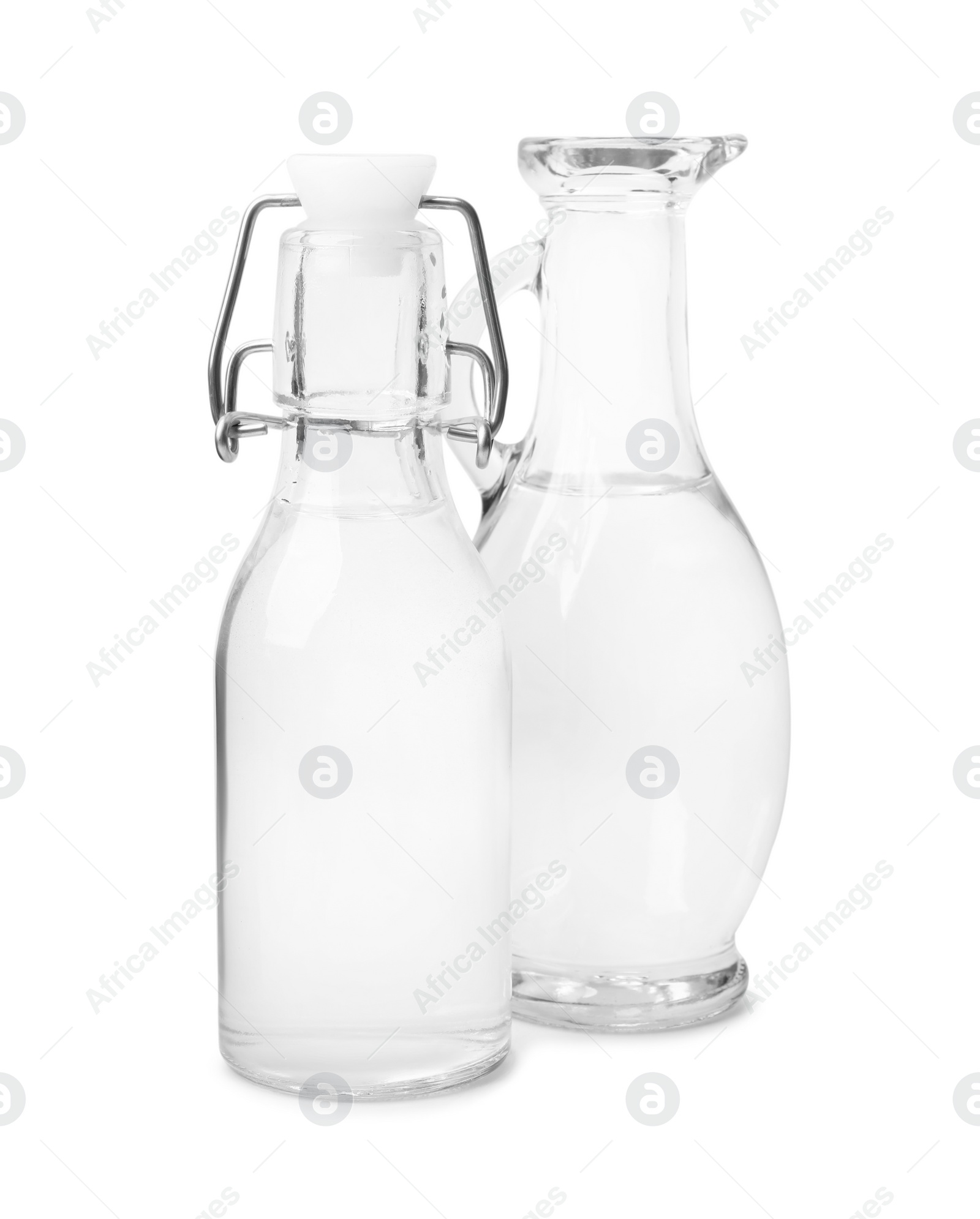 Photo of Vinegar in glass bottle and jug isolated on white