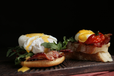 Photo of Delicious eggs Benedict served on wooden board, closeup