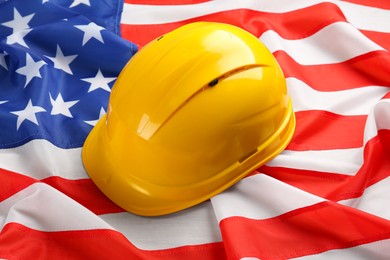 Photo of Yellow protective hard hat on American flag, closeup