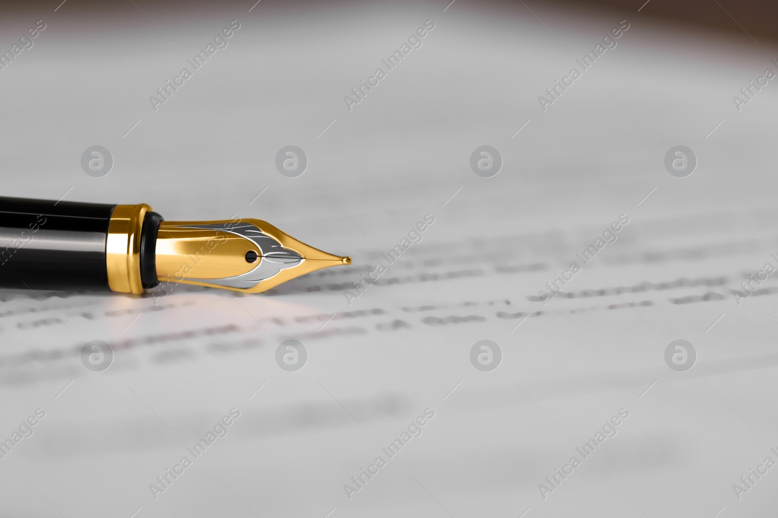 Photo of Fountain pen on document, closeup and space for text. Notary contract