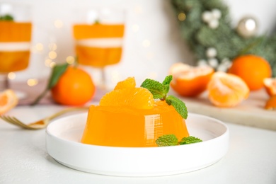 Photo of Delicious tangerine jelly with mint on white table