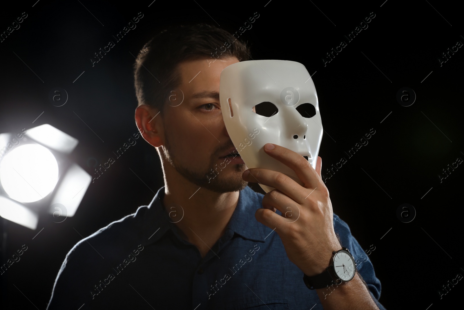 Photo of Professional actor with mask on stage in theatre