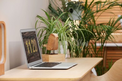 Photo of Cozy workspace with laptop on wooden desk at home