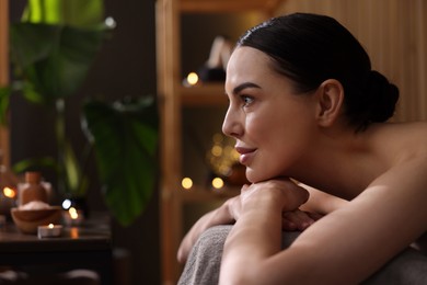 Photo of Spa therapy. Beautiful young woman lying on massage table in salon, space for text