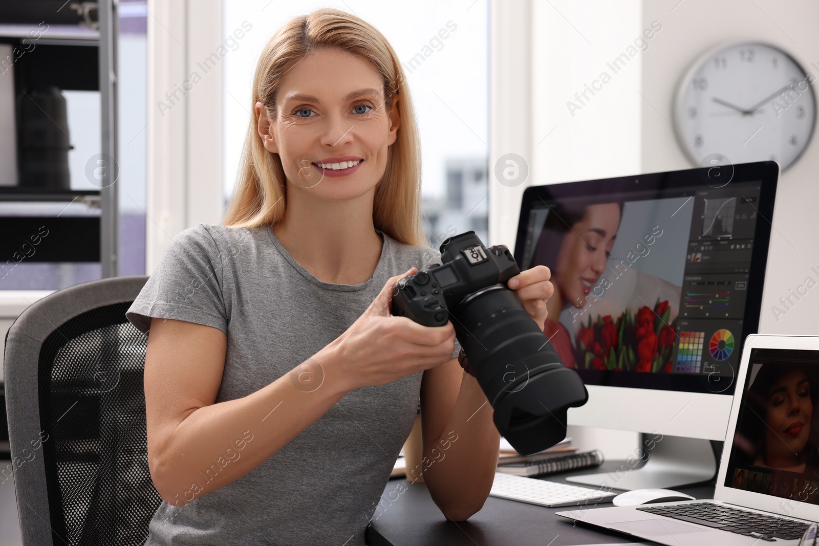 Photo of Professional photographer with digital camera at table in office