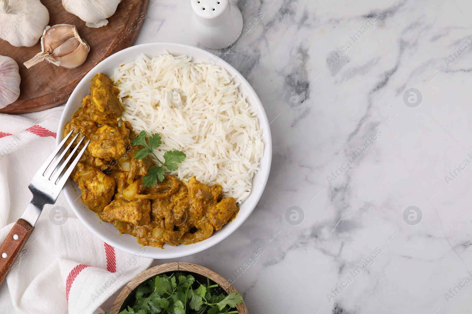 Photo of Delicious chicken curry with rice and ingredients on white marble table, flat lay. Space for text