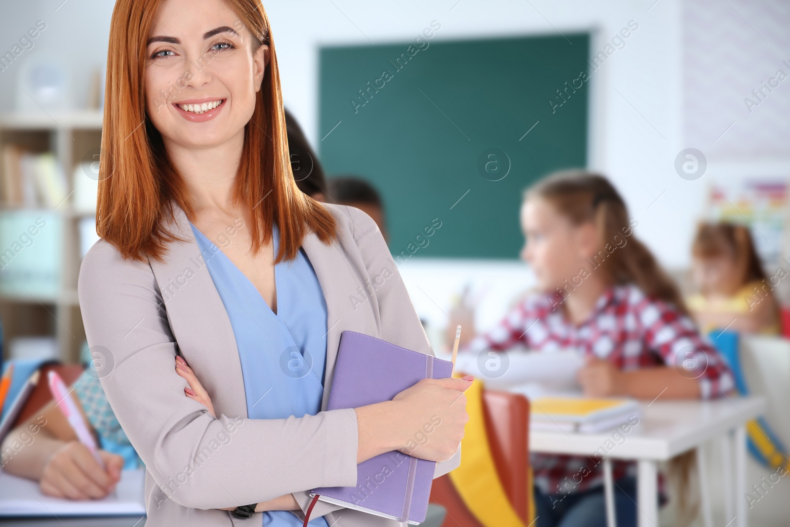 Image of Happy school teacher in classroom with students