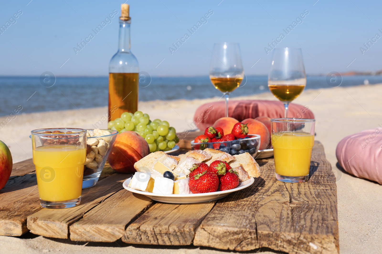 Photo of Food and drinks on beach. Summer picnic