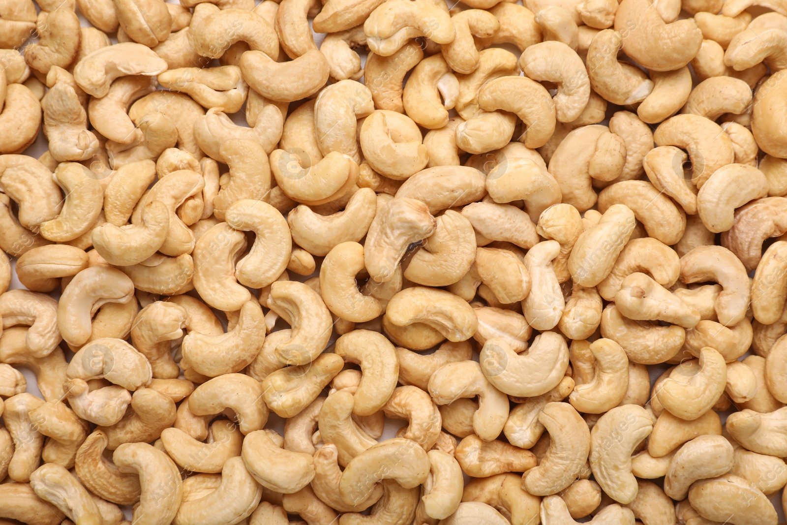 Photo of Many tasty cashew nuts as background, top view