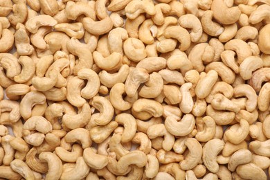 Many tasty cashew nuts as background, top view