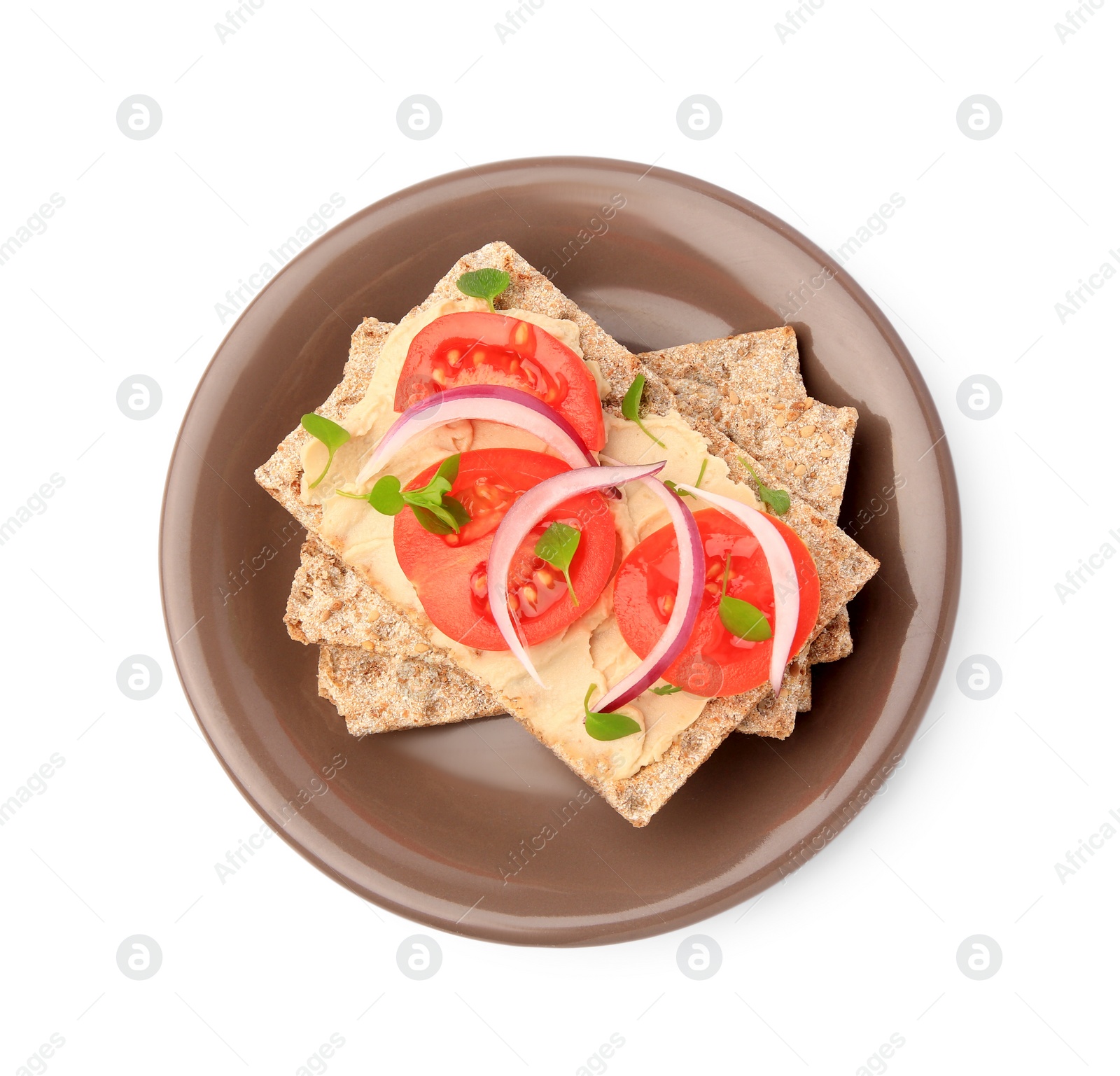 Photo of Fresh crunchy crispbreads with pate, tomatoes, red onion and greens isolated on white, top view