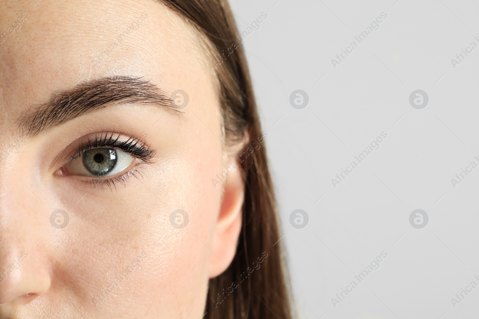 Photo of Closeup photo of woman with beautiful eyes on light background. Space for text