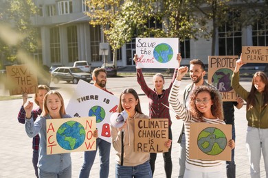 Group of people with posters protesting against climate change on city street