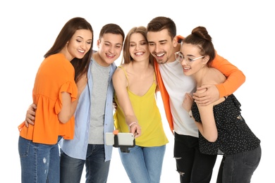 Photo of Young happy friends taking selfie against white background