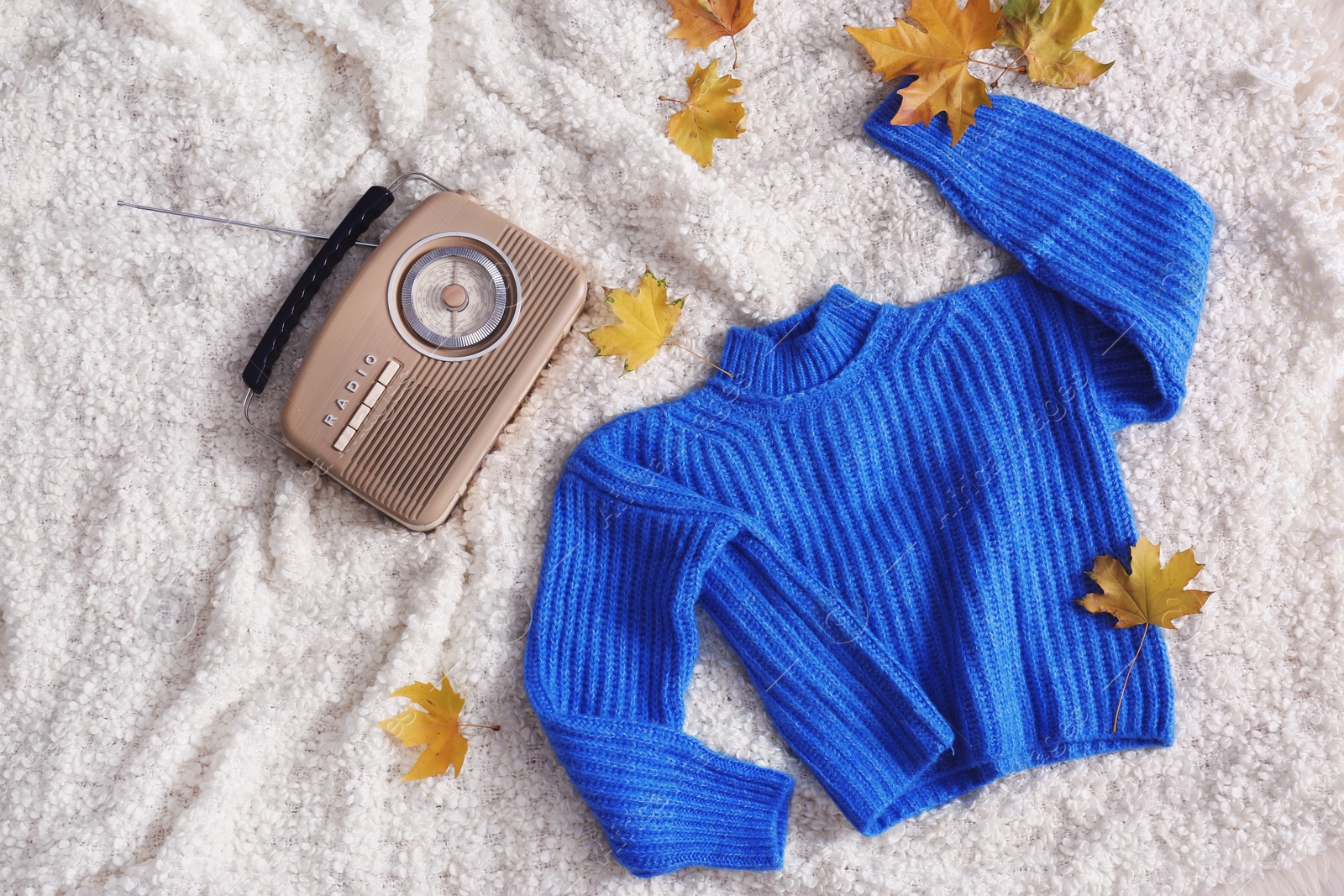 Photo of Flat lay composition with warm sweater and autumn leaves on soft plaid