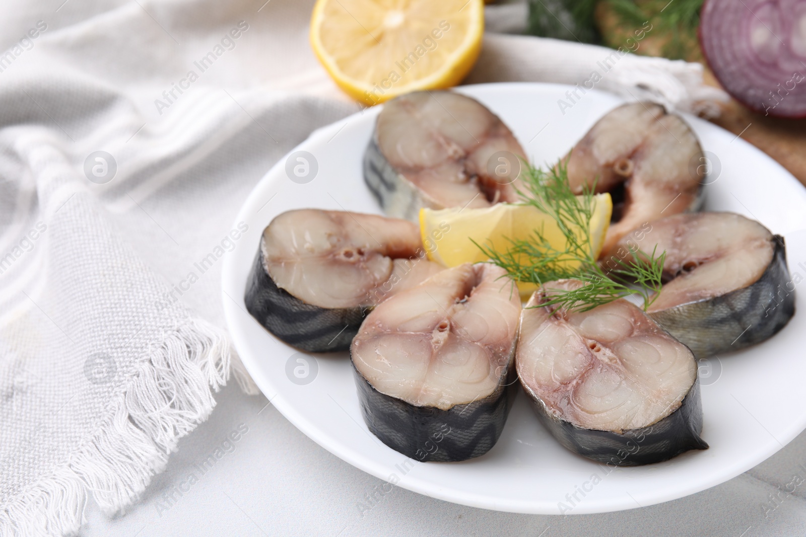 Photo of Slices of tasty salted mackerel, dill and lemon wedge on white table, closeup