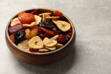 Photo of Mix of delicious dried fruits on grey table, closeup. Space for text