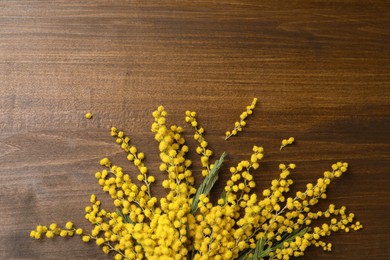 Photo of Beautiful mimosa flowers on wooden table, flat lay. Space for text