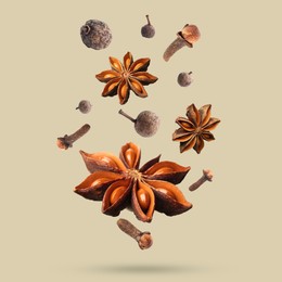 Image of Different spices falling on dark beige background