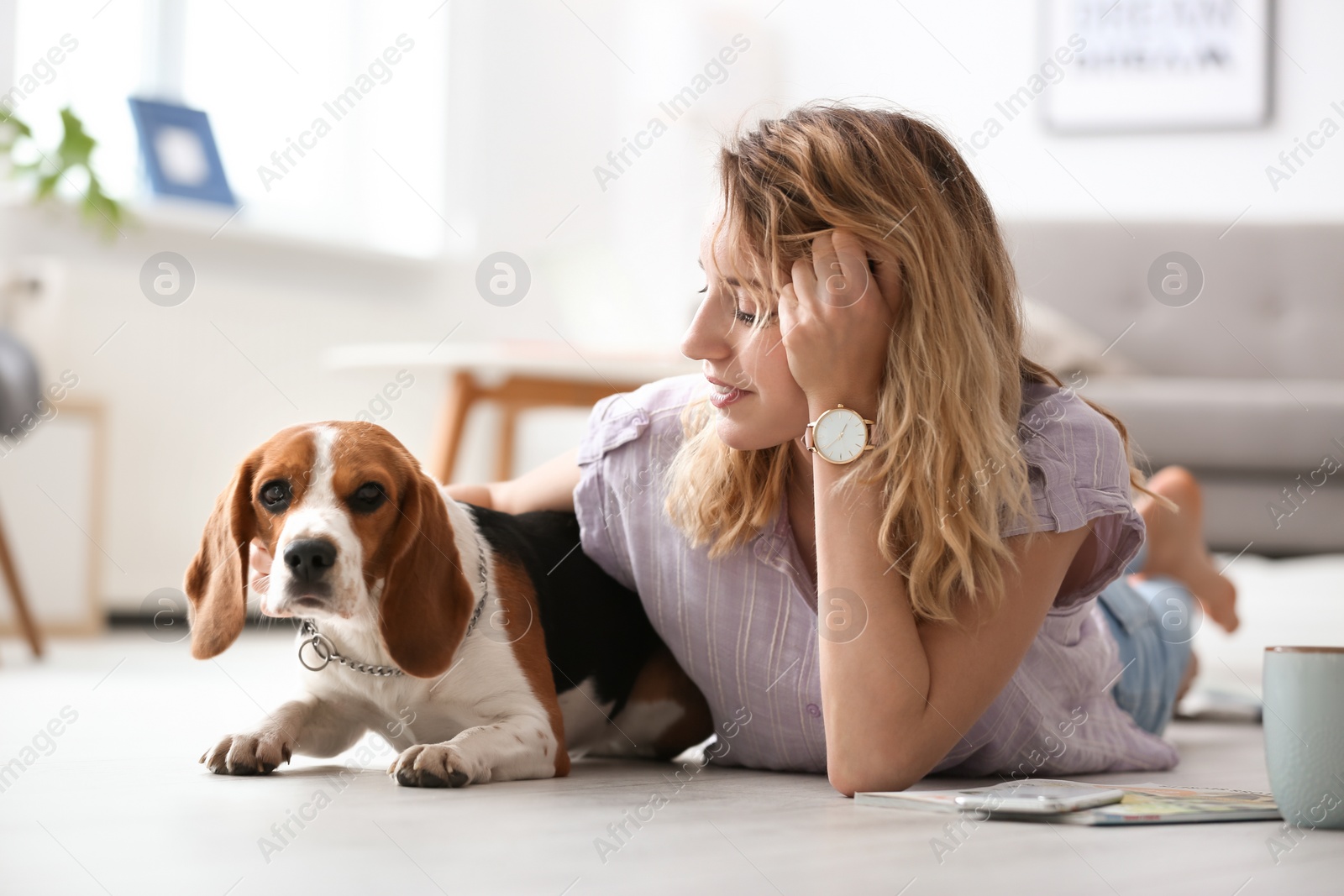 Photo of Young woman with her dog at home