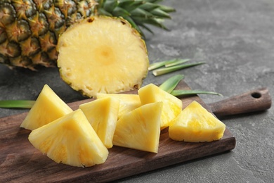 Photo of Wooden board with fresh sliced pineapple, closeup