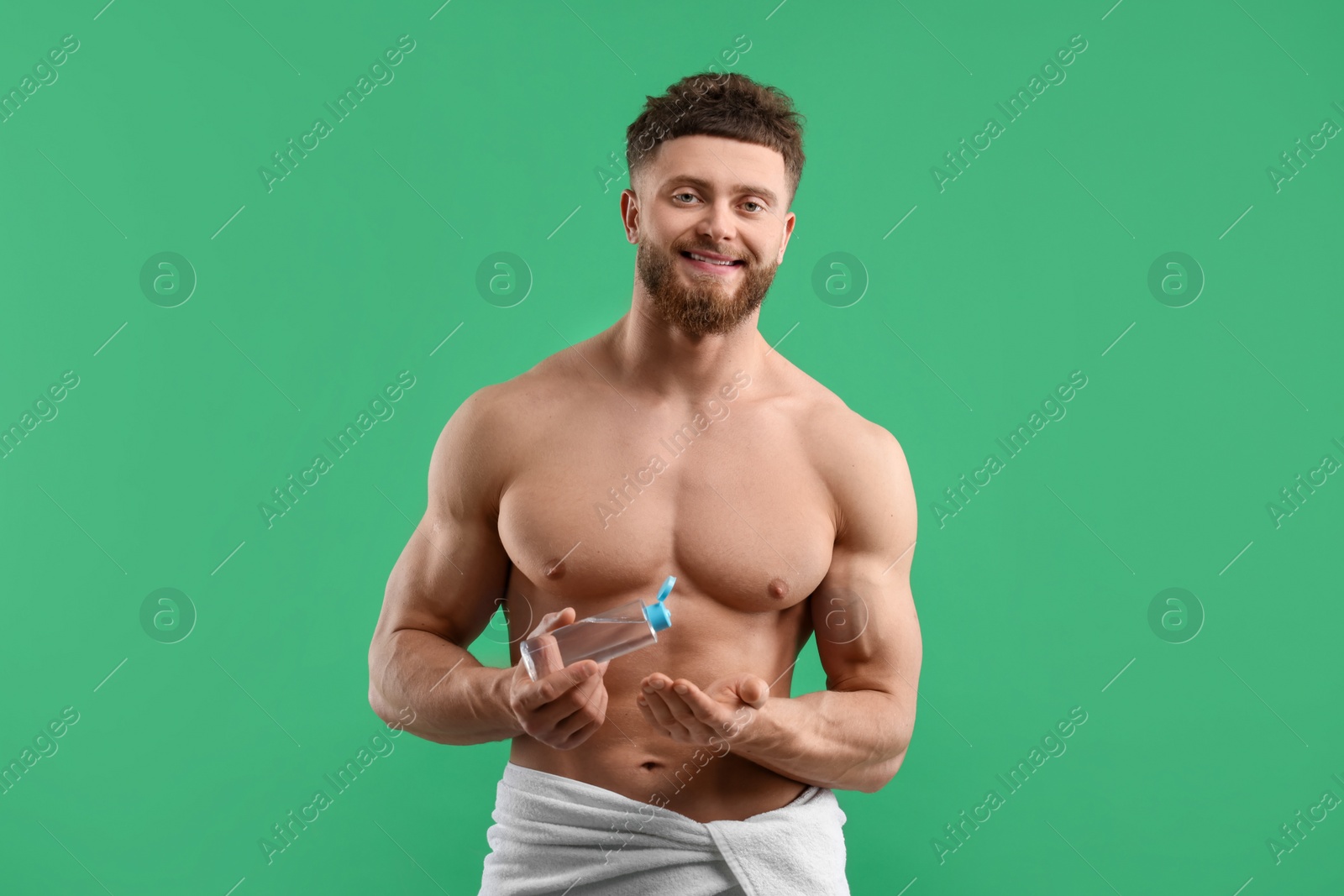 Photo of Handsome man with body lotion on green background