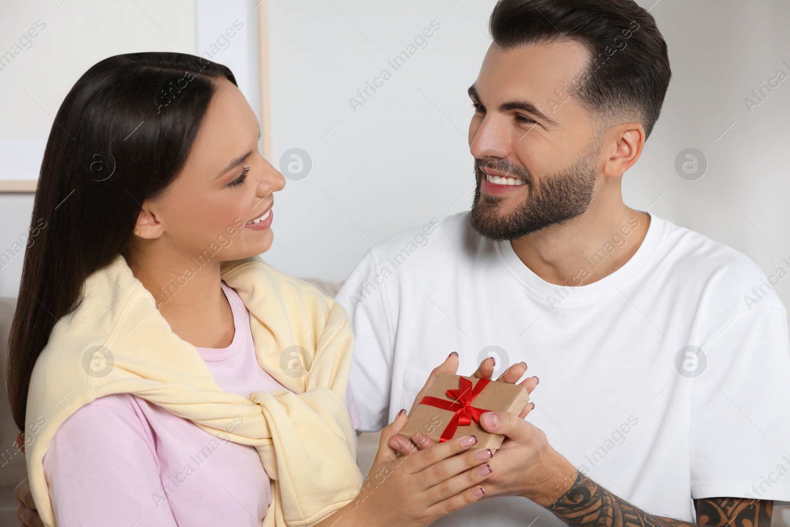 Photo of Lovely couple with beautiful gift at home