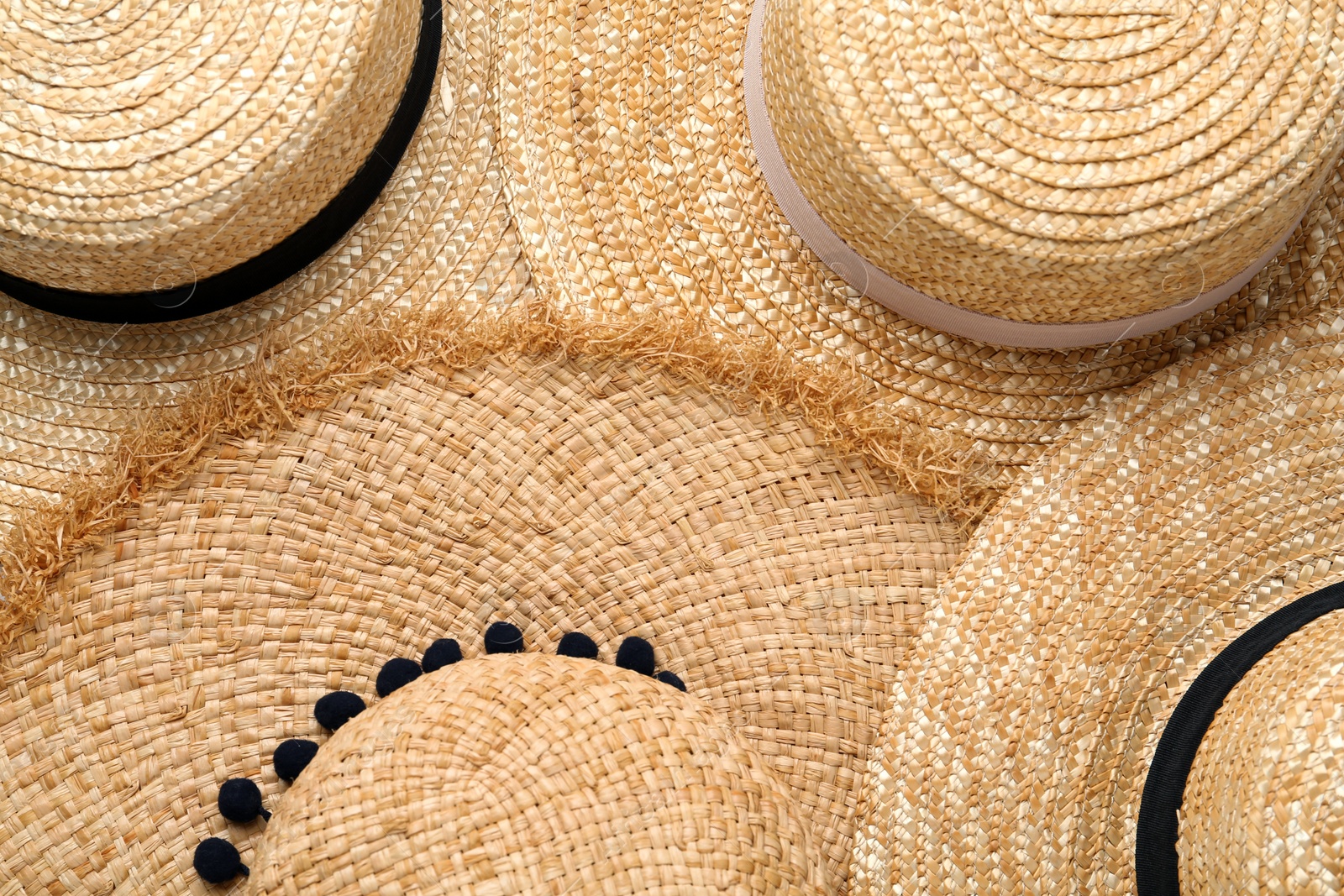 Photo of Many different straw hats as background, top view